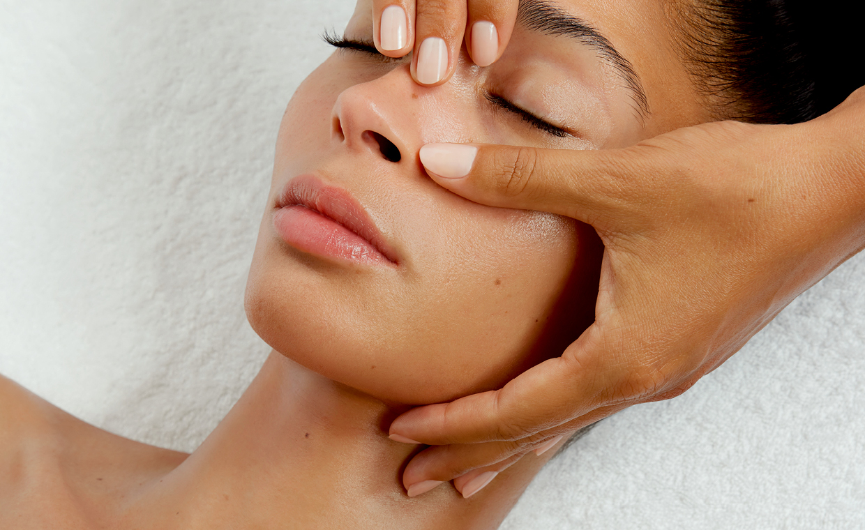 Nahaufnahme Gesicht von Frau, die im Kosmetikstudio auf einer Liege behandelt wird