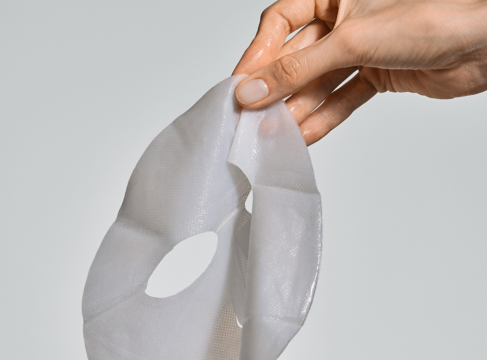 Tuchmaske in der Hand