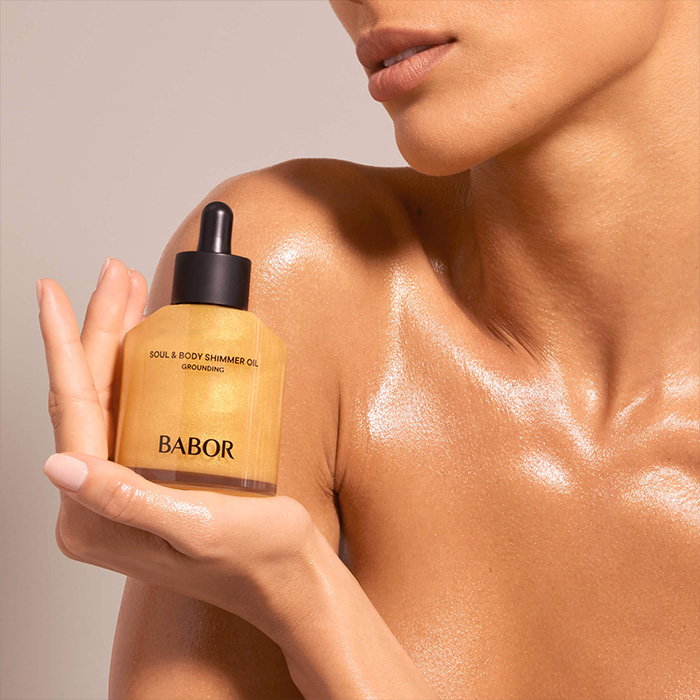Close Up schimmernde schöne Haut mit BABOR Body Oil in der Hand